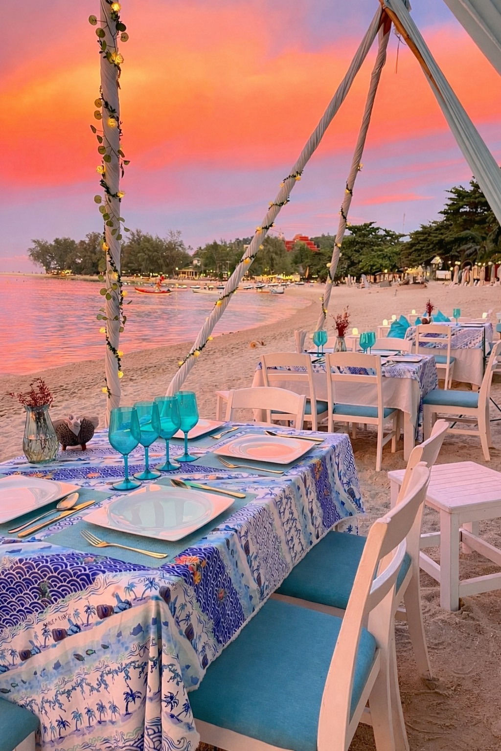 Intimate ceremony under a tent canopy — orange sunset over the bay